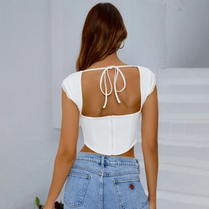 Top a corsetto bianco con schiena scoperta, pizzo e fiocco decorativo sul retro