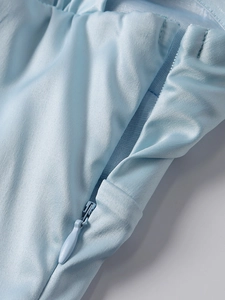 Détail d'une fermeture éclair invisible sur une robe en satin bleu clair soyeux