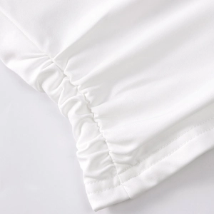 Detailed close-up of white ruched fabric texture and stitching on the mini skirt