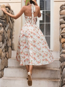 Dettaglio della stampa floreale su abito bianco con scollo all'americana e schiena nuda