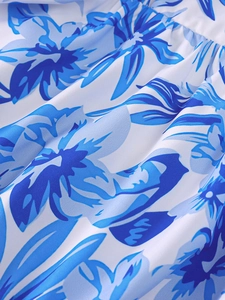 Gros plan du tissu plissé de la robe d'été avec motifs floraux bleus sur fond blanc
