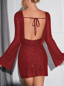 Détail d'une robe rouge à paillettes dos nu avec manches évasées et lien de serrage fin