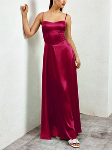Detail of the satin maxi dress featuring a cutout waist and luxurious burgundy fabric