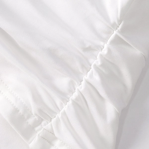 Close-up of white gathered fabric detail with precise parallel stitching and micro-texture