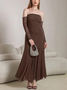 Détail de robe élégante marron foncé épaules dénudées avec manches en tulle et fronces