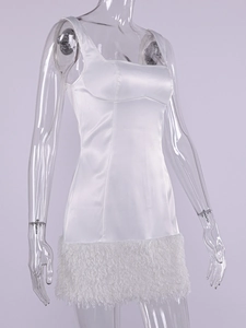Détail de la robe en satin blanc avec col carré et bordure élégante en plumes au bas