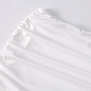 Close-up detail of white milk silk fabric showing elastic ruched texture and fine stitching