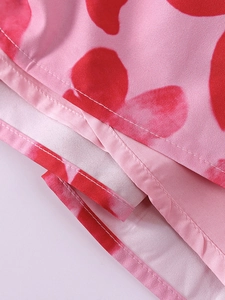 Détail de la robe à imprimé floral rouge et rose avec ourlet à double couture de qualité