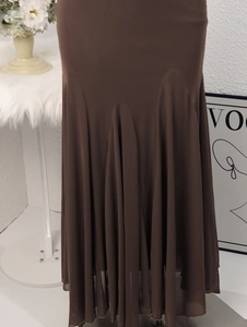 Détail d'une robe longue en tulle marron foncé avec un ourlet sirène élégant à volants