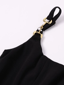 Detail of elegant gold horsebit buckle on black strap of square neck summer dress