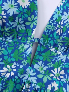 Detail of blue floral dress featuring deep V-neckline and intricate daisy print fabric