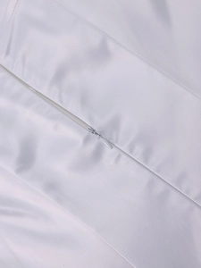 Gros plan détaillé de la fermeture éclair invisible sur une robe courte en satin blanc