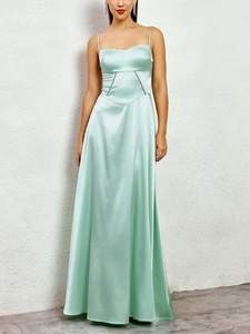 Detail of light green satin maxi dress showing the side cut-outs and soft silk texture