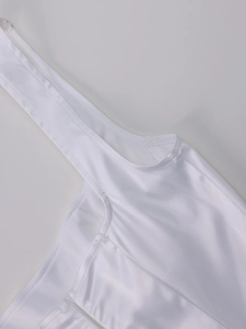 Détail de caraco blanc en satin avec fines bretelles et texture de tissu délicate