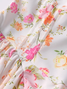 Dettaglio dell'abito estivo a fiori con cuciture parallele e trama del tessuto plissettato