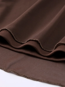 Détails macro du tissu en maille marron foncé montrant des bords ondulés et une texture fine