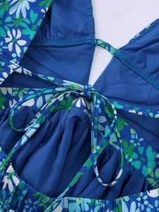 Detail of floral printed halter dress featuring adjustable ties and pleated fabric texture
