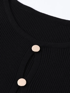 Detail of ribbed knit neckline featuring a keyhole cutout and elegant gold button accents