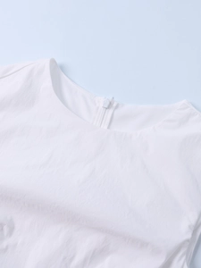 Detail view of white crew neck dress showing invisible back zipper and textured fabric