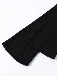 Detailed macro shot of the black ribbed knit fabric showing soft texture and elasticity