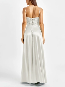 Close-up of the elegant corset back with criss-cross lacing on the white satin maxi dress