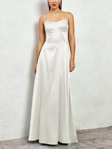 Close-up of matte satin fabric texture and sequin waist detail on white formal dress