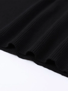 Close-up of black ribbed knit fabric showing the texture and premium stitching detail