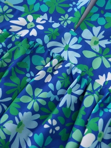 Macro shot of blue floral print fabric with ruched details on a beach style dress