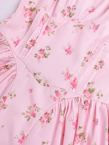 Dettaglio vestito floreale rosa con cucitura a V in vita e trama del tessuto a pieghe