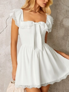 Close-up of the square neck white dress featuring lace trim and a large decorative bow