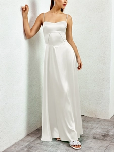Detailed view of white matte satin maxi dress featuring thin straps and elegant draping