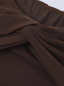 Detail of dark brown mesh fabric featuring intricate knot design and pleated texture