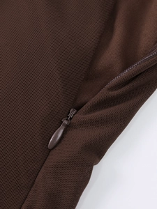 Détail de la fermeture éclair invisible sur le tissu en maille marron de la robe