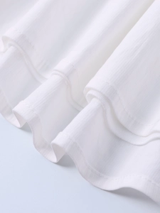 Detailed macro view of white tencel fabric showing vertical textures and ruffle layers