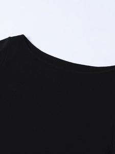 Détail de l'encolure en maille côtelée de haute qualité et de l'épaule sur la robe noire