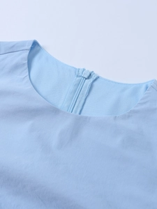 Detail of round neckline and back zipper on light blue Tencel textured mini dress