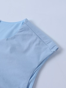 Detailed close-up of light blue dress shoulder seam and textured tencel fabric