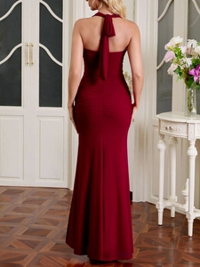 Détail de la robe en maille bordeaux avec licou, dos nu et design froncé moulant