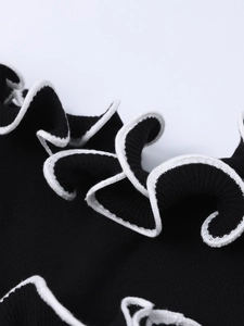 Gros plan sur maille noire avec bordure blanche contrastante et détails de volants ondulés