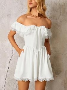 Detail of white off-shoulder mini dress with large bow and delicate lace trim