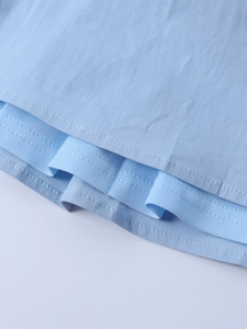 Detailed macro view of light blue tencel dress showing precise double-row stitching hem