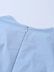 Macro shot of invisible zipper detail on light blue twill fabric of the short dress