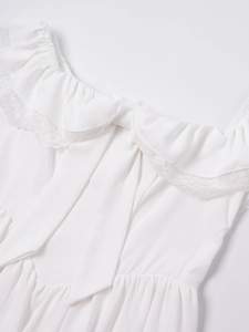 Detailed view of white lace trim neckline with ruffled edges and bow tie on the dress