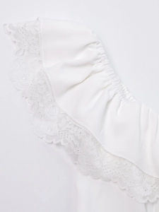 Macro detail of white summer dress showing delicate lace trim and elastic ruffles