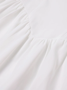 Detailed close-up of delicate white dress pleats and premium chiffon fabric texture