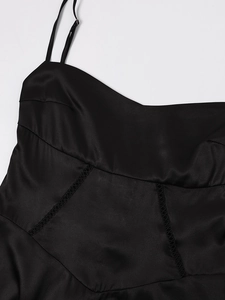 Detail of black satin dress featuring a structured sweetheart neckline and delicate stitching