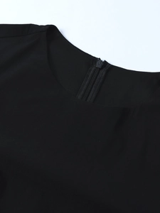Close-up of crew neckline and invisible back zipper on black tencel dress fabric