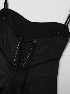 Close-up of black satin dress back with lace-up corset detail and metallic eyelets