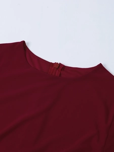 Détail du tissu en maille bordeaux avec fermeture éclair invisible sur la robe chic