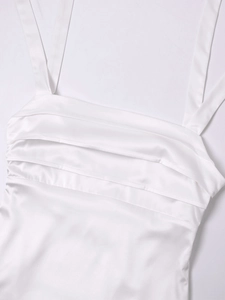 Detail view of white satin summer dress featuring elegant triple layered ruffle chest design